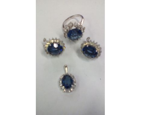 Silver dress ring together with mathcing earrings and pendant, set with blue gemstones 