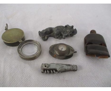 A small collection of items including a double horn whistle, compass and magnifying glass combination, lead cat figure group 