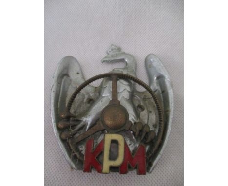 A vintage Polish Automobile Club car badge with eagle holding a steering wheel with enamelled "KPM"