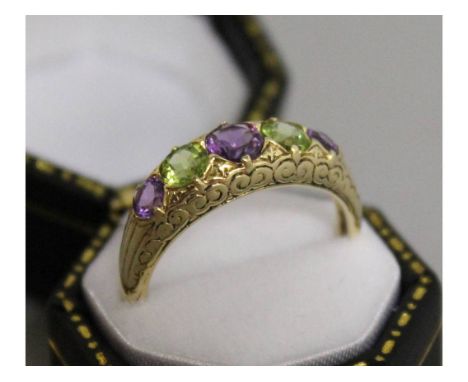 A 9CT YELLOW GOLD AMETHYST AND PERIDOT RING.