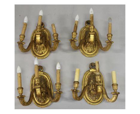 A GOOD SET OF FOUR LOUIS XVI CARVED WOOD AND GILDED THREE LIGHT WALL SCONCES, with oval backs and acanthus mounts.  15ins lon