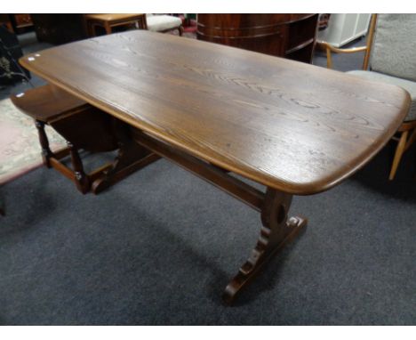 An Ercol elm dining table with under stretcher 