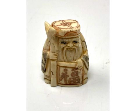 A carved Chinese bone netsuke - village elder with scroll and staff