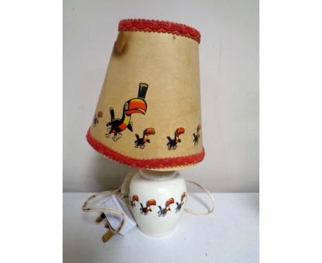 A Guinness table lamp and shade decorated with toucans   