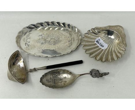 A shell shaped dish, Birmingham 1903, a caddy spoon, a sifter spoon, and an oval tray, various dates and marks, all in 6.18 o