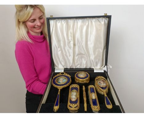 An impressive early 20th century gilt metal and blue enamel dressing table set, inset with portrait miniatures of ladies, com