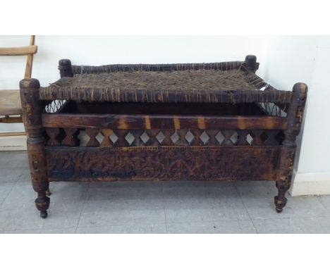 An Indian, rustically constructed daybed with a woven hide surface&nbsp; 19"h&nbsp; 35"w 