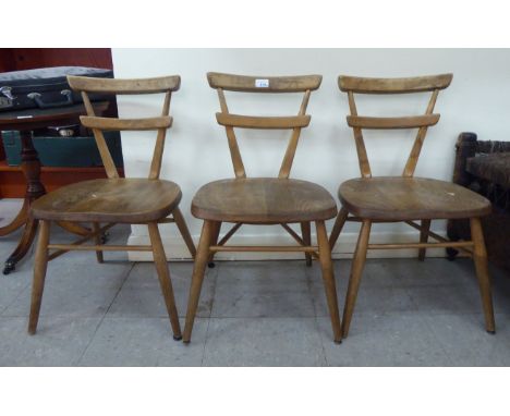 A children's' set of three mid 20thC Ercol beech and elm framed, double bar back&nbsp;stacking chairs, the solid seats raised