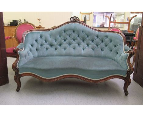 A late 19thC Continental walnut showwood framed, serpentine front salon settee with a part button upholstered blue fabric bac