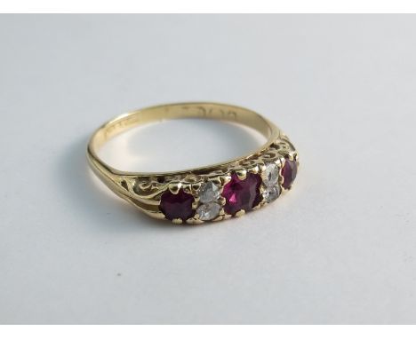 An 18ct yellow gold diamond and ruby ring, scroll mount 