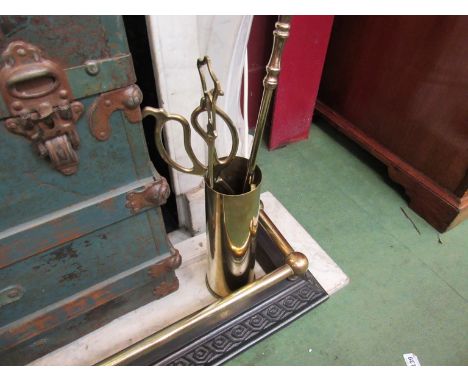 A brass and iron fender with fire tools 