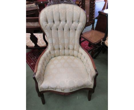 A Victorian button-back chair, with carved floral crest silk upholstery