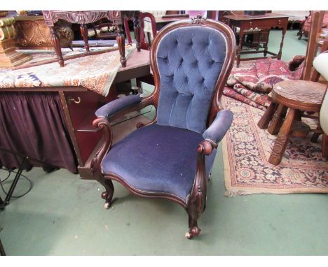 A mid-Victorian button spoon backed walnut armchair, the scroll arms and serpentine front seat on carved supports and white c