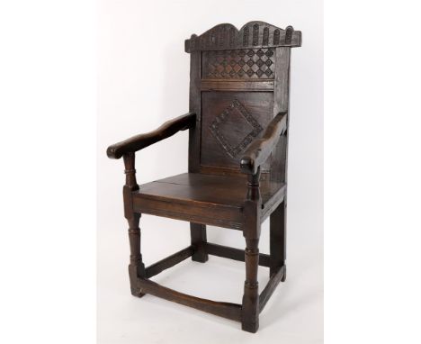 
	
		A 17th century and later oak 'wainscot' armchair, possibly Welsh, the arched serpentine top rail above roundel carved pa