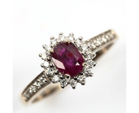 A modern 18ct white gold ruby and diamond oval cluster ring, set with oval mixed-cut ruby and modern round brilliant-cut diam