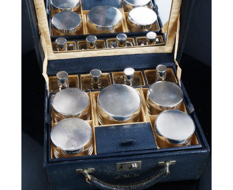 A George VI leather vanity case, by Finnigans of Bond Street London, containing 9 silver-topped dressing table toilet jars, w