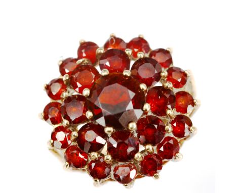 A large 9ct gold garnet cluster ring, set with round-cut garnets, setting height 20.3mm, size N, 5.4gNo damage or repairs, al