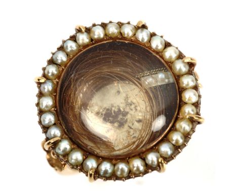 A large 19th century pearl cluster mourning ring, central hair panel beneath convex crystal with border of split pearls and u