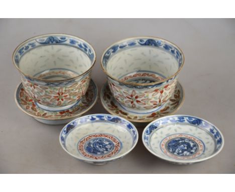 A pair of Chinese grains de riz bowls, stands and covers, each decorated with flowers and foliage, Kangxi six character marks