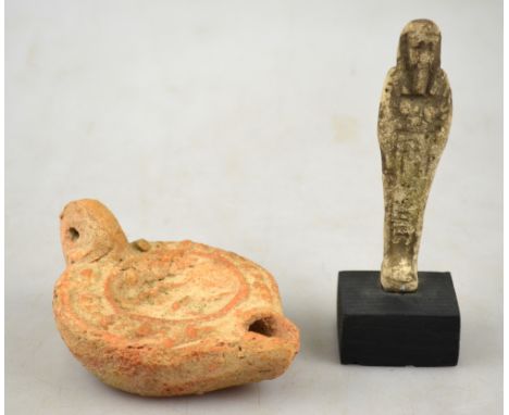 An Egyptian faience Ashabti (reputedly circa 600 BC), with vestigial glaze, 9 cm, to/w a Roman terracotta oil-lamp (2)