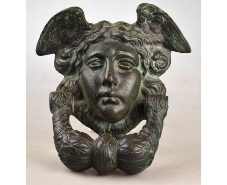 A heavy cast metal door-knocker, modelled as a winged Mercury mask with hinged wreath, 21 x 18 cm Condition Report Good well 