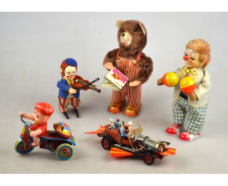 Three Japanese clockwork toys:- Clown with maracas, bear with nursery book, and boy on tricycle with bell, to/w a German clow