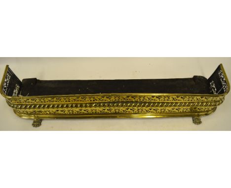 A Victorian pierced brass hearth fender raised on cast paw feet, 120 cm wide x 30 cm x 21 cm high