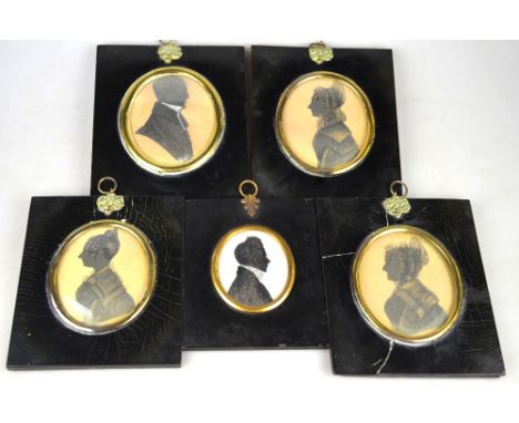 A family set of four Regency oval painted portrait silhouettes of a clerical gentleman, his wife and two daughters (possibly)