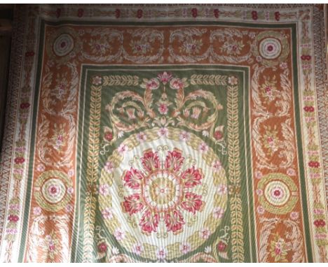 An aubusson design needlework carpet, the green ground centred with a floral burst within multi-coloured borders, 292 x 220 c
