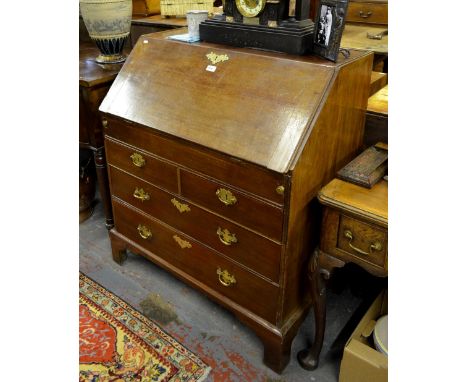 An 18th century mahogany bureau, the hinged slope enclosing an interior of drawers and niches over a slide top storage well, 