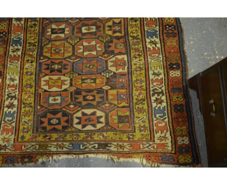 An antique Caucasian long rug, the repeating geometric design on brown ground within three wide multi-coloured borders, 2.50 