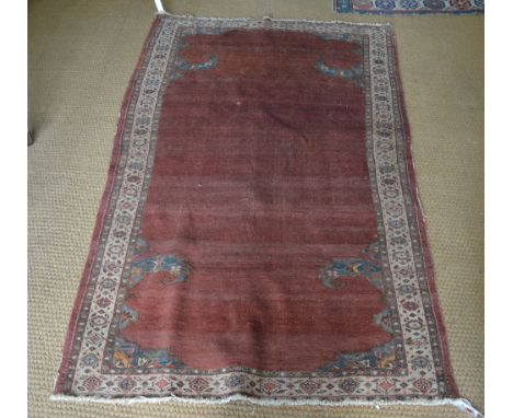 An antique Persian  rug, the plain rust field with trailing corners, 1.75 x 1.15 m Condition Report good even wear, losses to