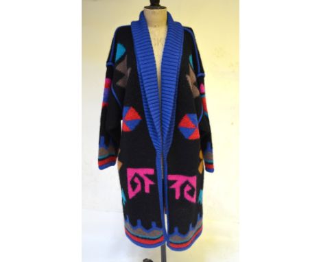 A 1980's heavy knitted wool coat with abstract pattern in vibrant blue/pink/red on a black ground, size M by Excel Condition 