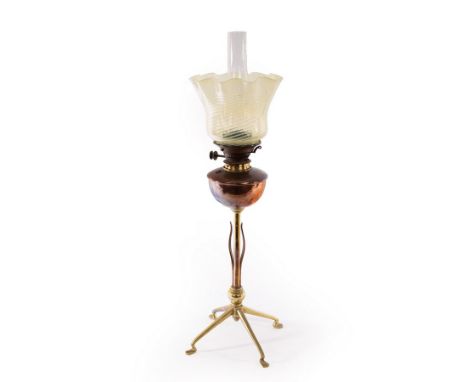 WAS Benson, a copper and brass oil lamp with leaf decoration, on four feet, the wick adjuster marked Benson & Co, 56cm high, 