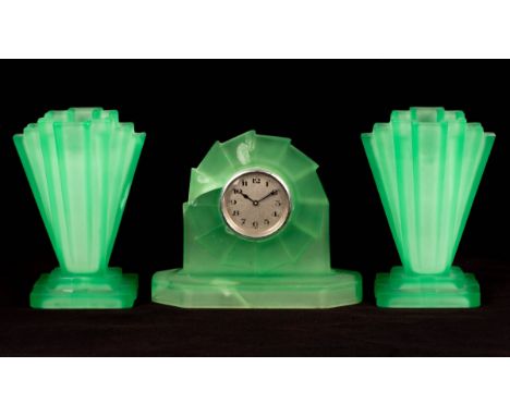 A group of 1930s pressed lime green glass, including dressing table items and a garniture of two vases and a clock of Art Dec