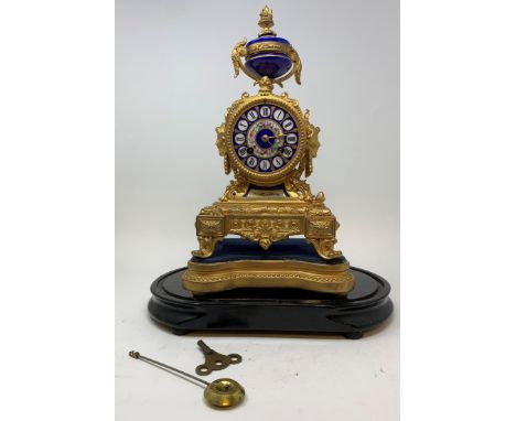 An early 20th century French mantle clock, with an 8 cm porcelain dial, decorated flowers, in a gilt metal case, 30 cm high o
