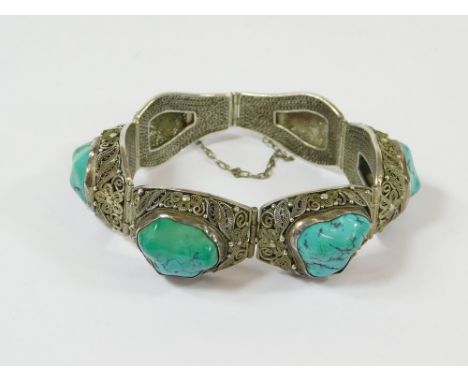 FILIGREE BRACELET. A silver filigree bracelet (possibly Chinese) set with four polished turquoise stones.  Please note that a