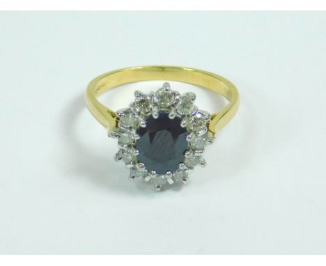 SAPPHIRE RING. An 18ct. gold sapphire & diamond cluster ring. Size R/S. Size of sapphire 9 x 6mm. Approx. 5.9g.  Please note 