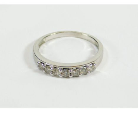DIAMOND RING. A white 18kt, half hoop diamond ring. Total diamonds 0.50ct. Size R.  Please note that all items in this auctio