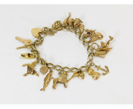GOLD CHARM BRACELET. A substantial 9ct. gold bracelet fastened with a 9ct. gold padlock clasp. Hung with 16 large charms, inc