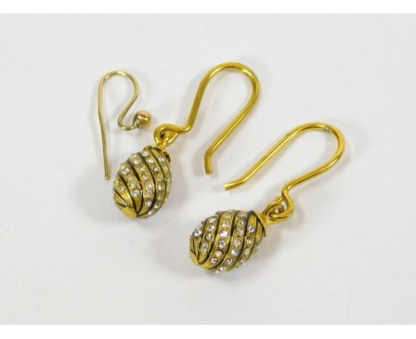 DROP EARRINGS. A pair of yellow metal drop earrings, set with clear stones between black enamel spirals. Hung on yellow metal