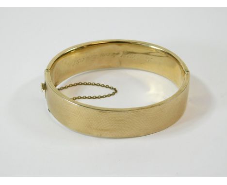 GOLD BANGLE. A 9ct. gold bangle with engine turned decoration. Approx. 21.5g.  Please note that all items in this auction are