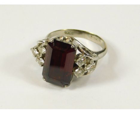 GOLD RING. An 18ct. white gold ring set a rectangular garnet, flanked with two groups of three diamonds. Size K.  Please note