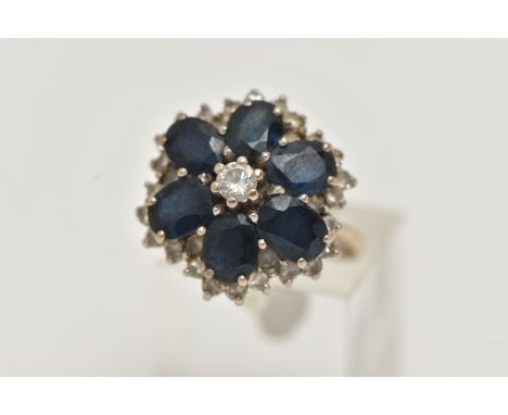 A LARGE 18CT GOLD SAPPHIRE AND DIAMOND CLUSTER RING, six oval cut sapphires and a central round brilliant cut diamond designe