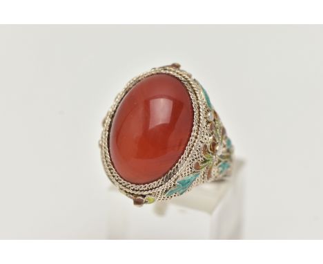 A WHITE METAL CARNELIAN AND ENAMEL DRESS RING, large oval carnelian cabochon, collet set to the fine mesh mount with enamel d