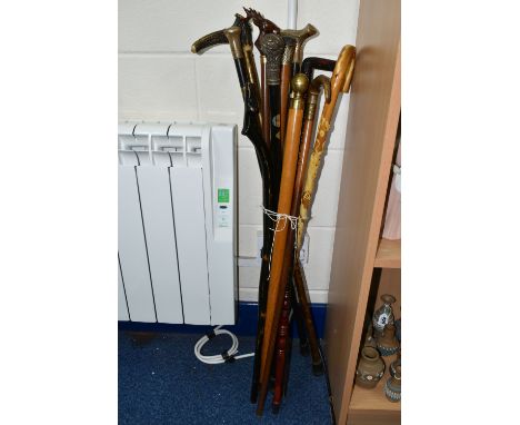 A GROUP OF TWELVE WALKING STICKS, comprising a Victorian walking stick with a carved horn handle and embossed gilt metal coll