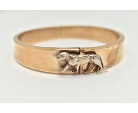 A HINGED BANGLE, the tapered hinged hollow bangle with wild cat push piece clasp, unmarked, approximate width at widest point