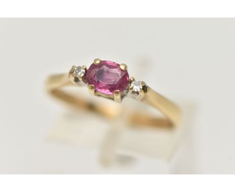 A 9CT GOLD RUBY AND DIAMOND RING, designed as a central oval shape ruby flanked by single cut diamonds, all within claw setti