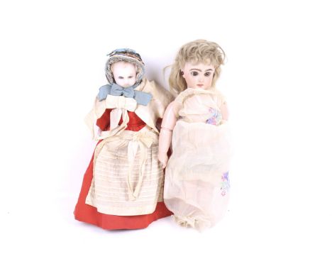 Two vintage dolls. Comprising one wax head doll in a red dress and blue bonnet together with a porcelain doll in a white flor