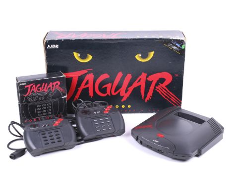 An Atari Jaguar games console. Comprising the console, two controllers and cables, plus a separate controller, all boxed.  Co